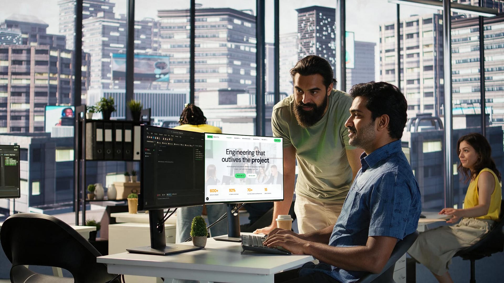 Two engineers working through something together at a desk