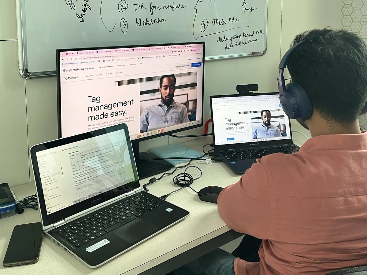 An engineer working across two screens beside a planning whiteboard