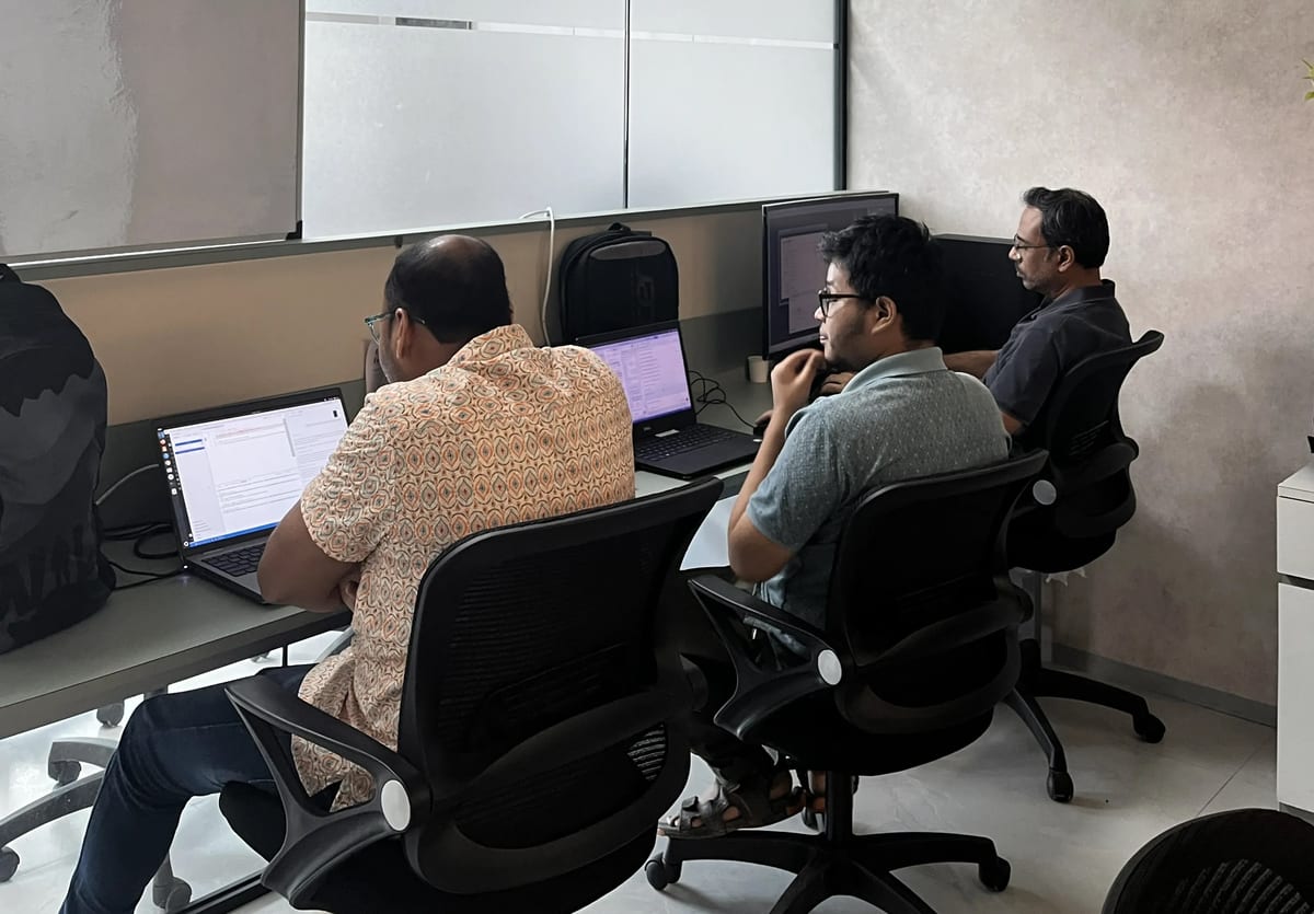 Three engineers working together at their desks