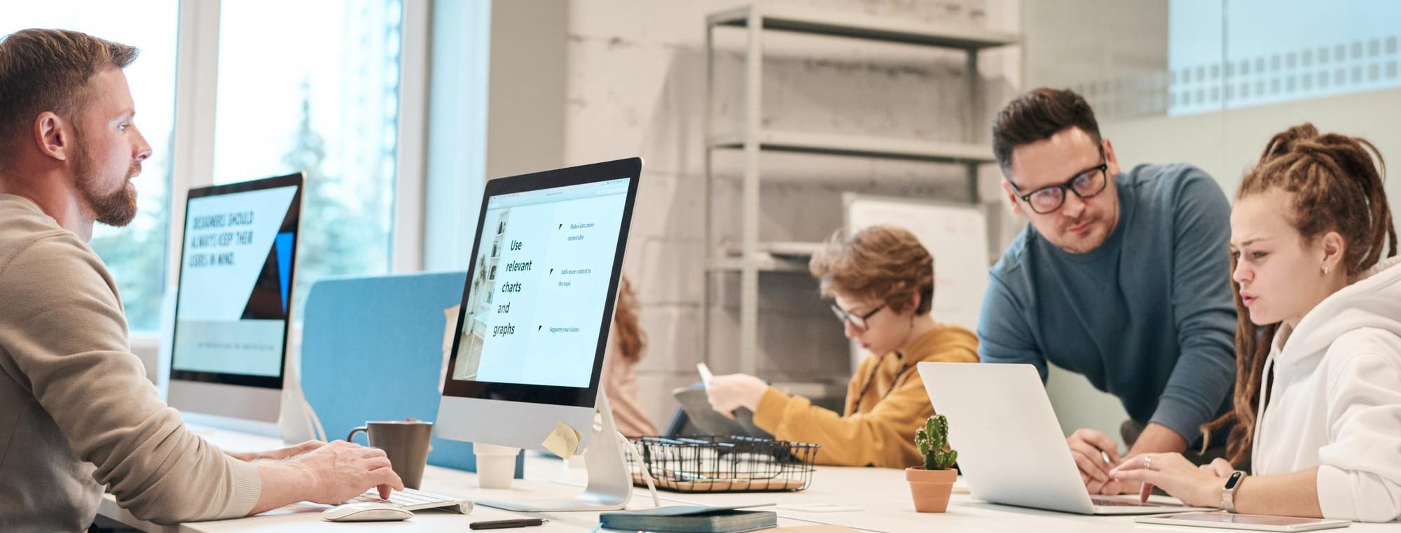 A team working across a shared bank of desks