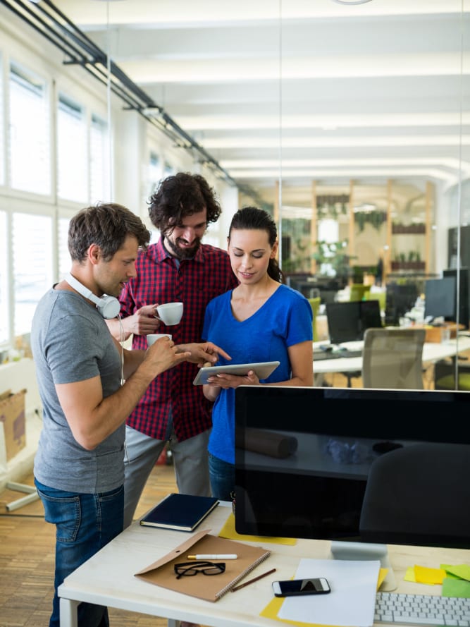 Three colleagues going through something on a tablet in the studio