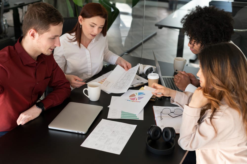 A team reading through plans and charts around a table