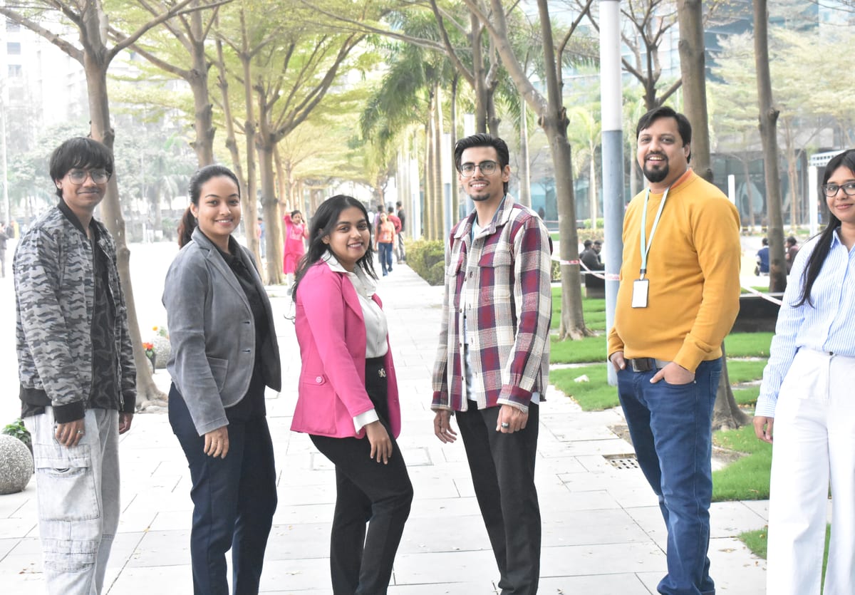 Six colleagues on the tree-lined walk outside the office